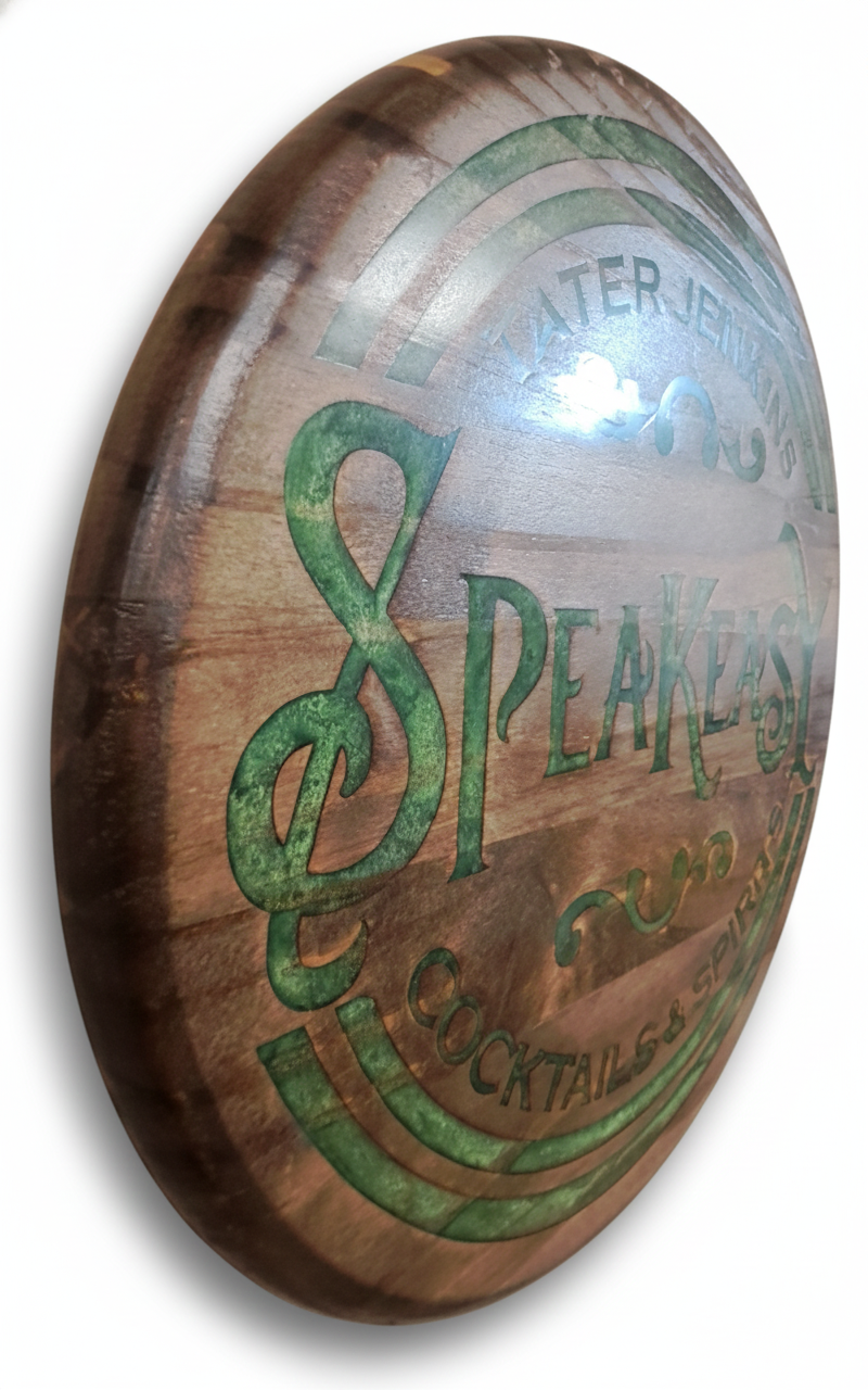 Wooden barrel head with green 'Speakeasy' logo on a white background
