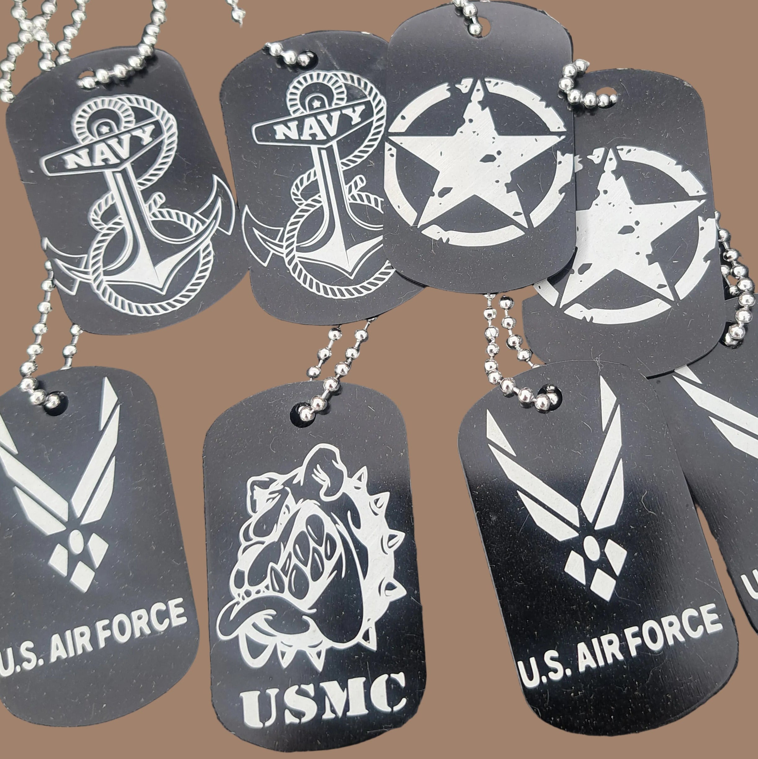 Black dog tags with white military symbols and text on a dark surface