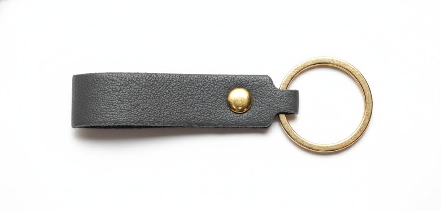 Gray leather keychain with a ring pictured on a white background