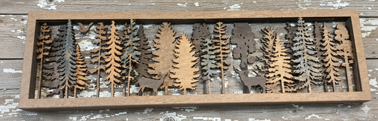 6 layers of wood, each layer has trees cut out in various places and each layer is stained a different color, the top layer has 2 deer silhouettes